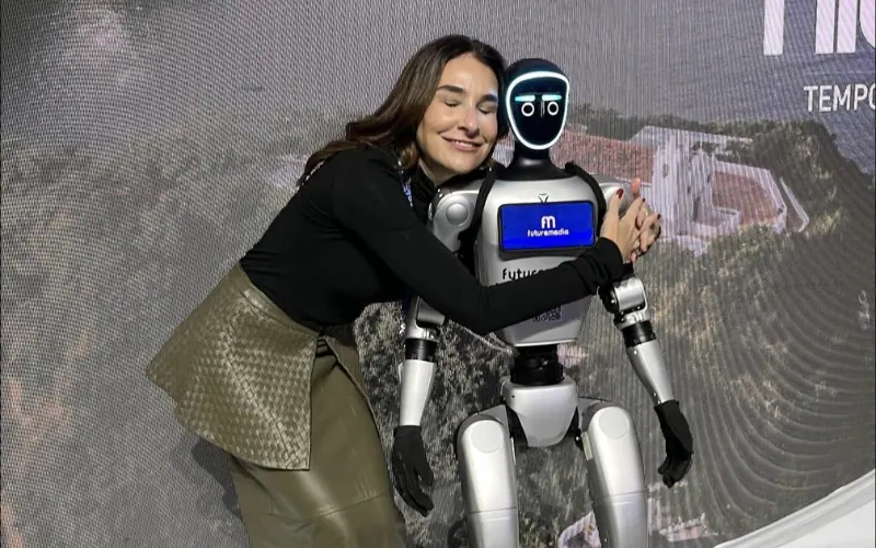 Juliana Benício ao lado de um robô humanoide em feira de tecnologia